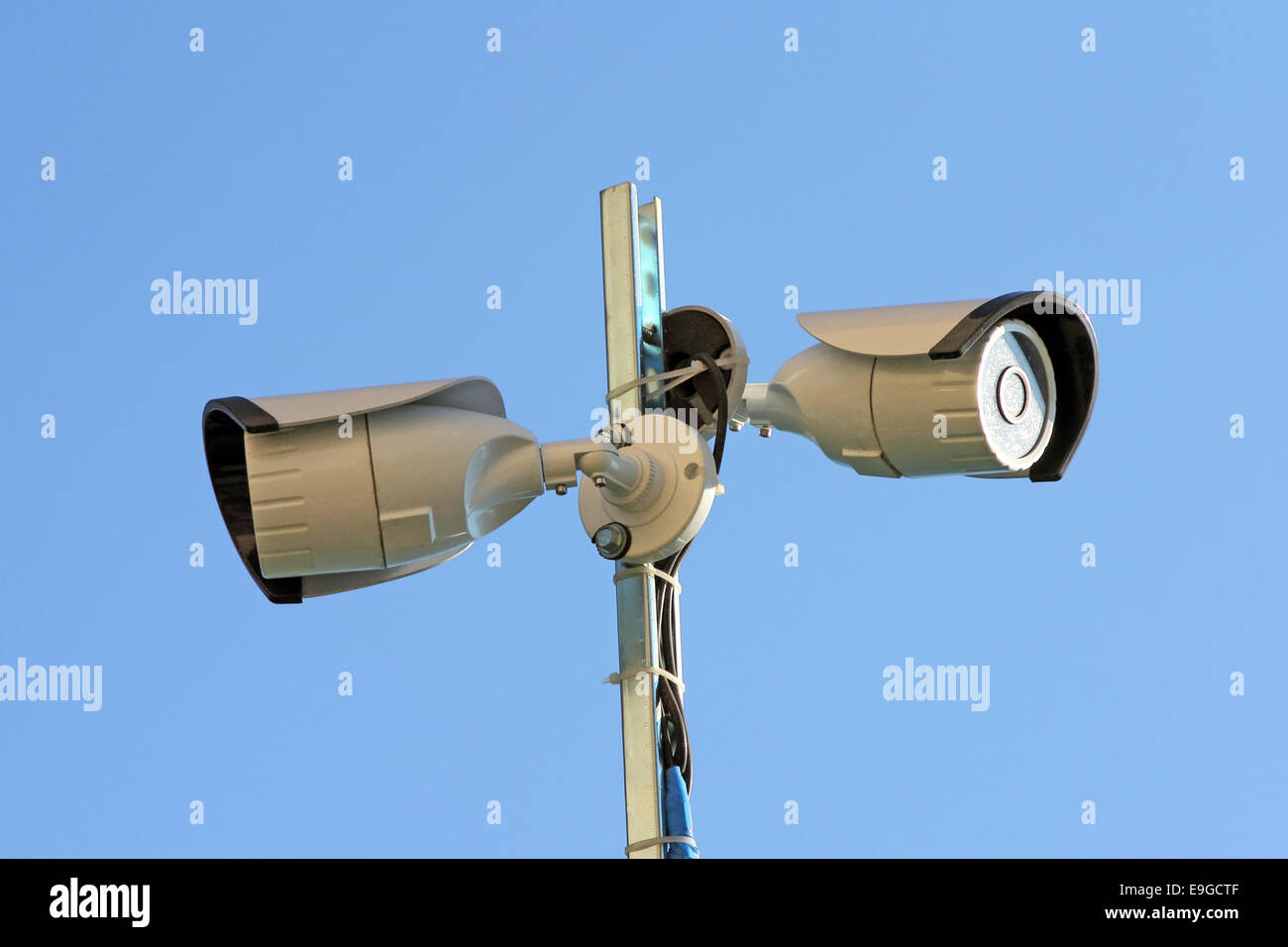 Two security cameras against blue sky Stock Photo