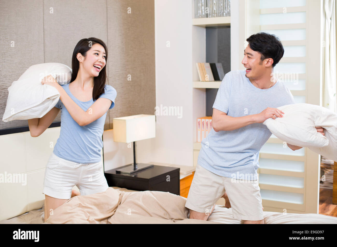Young couple pillow fighting in bedroom Stock Photo Alamy
