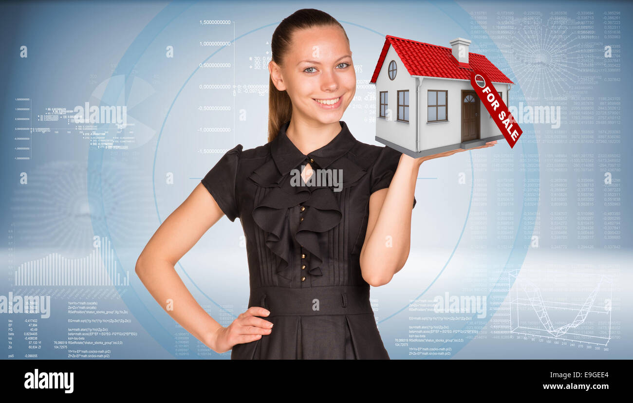 Businesswoman smiling and holding house in hand Stock Photo - Alamy