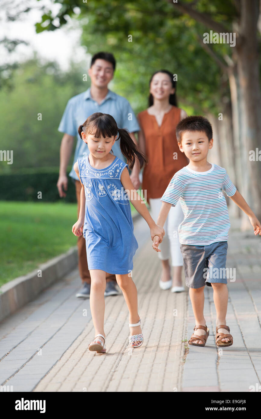 Happy brother and sister holding hands walking Stock Photo - Alamy