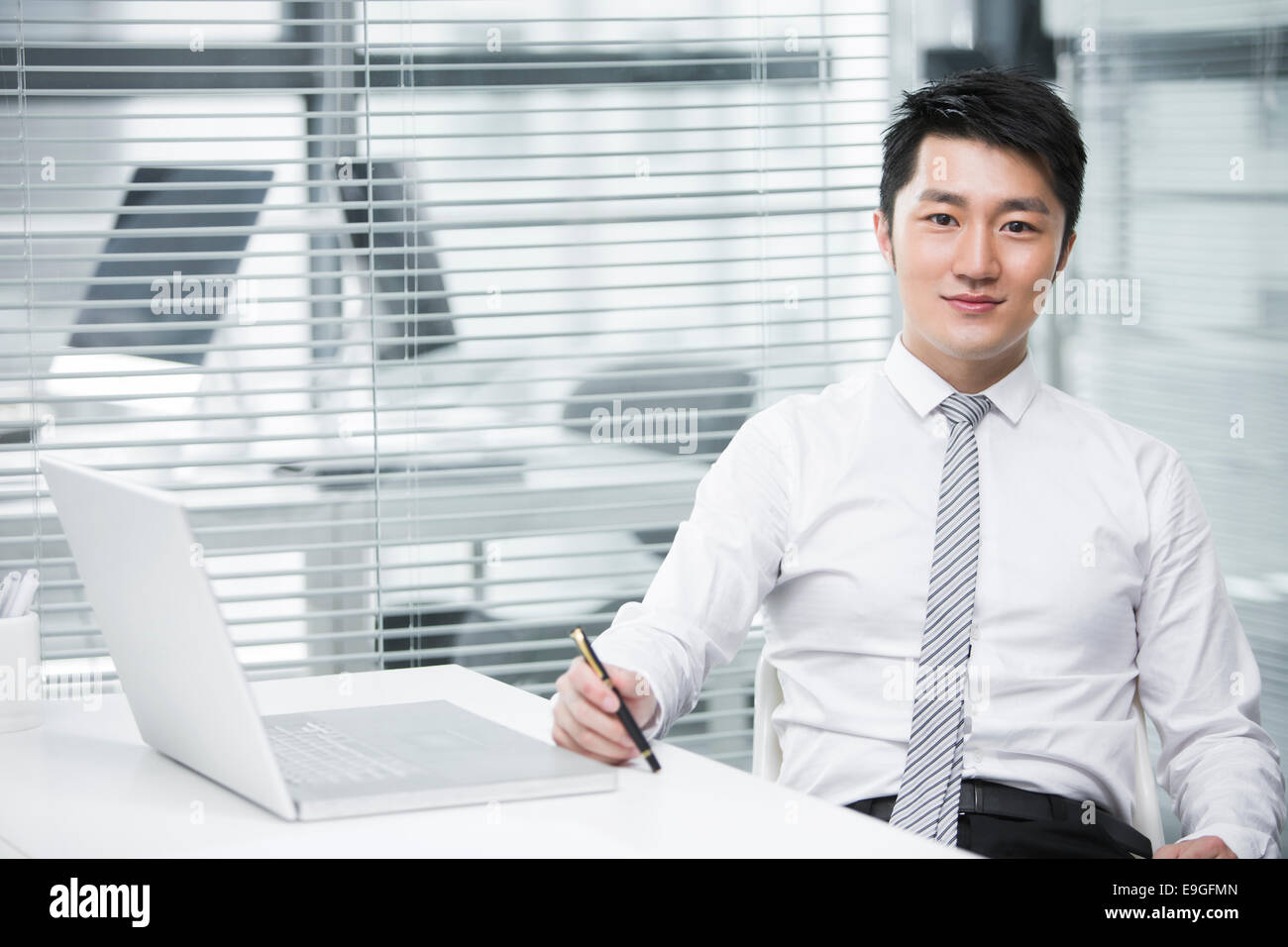 Young businessman holding a pen Stock Photo - Alamy
