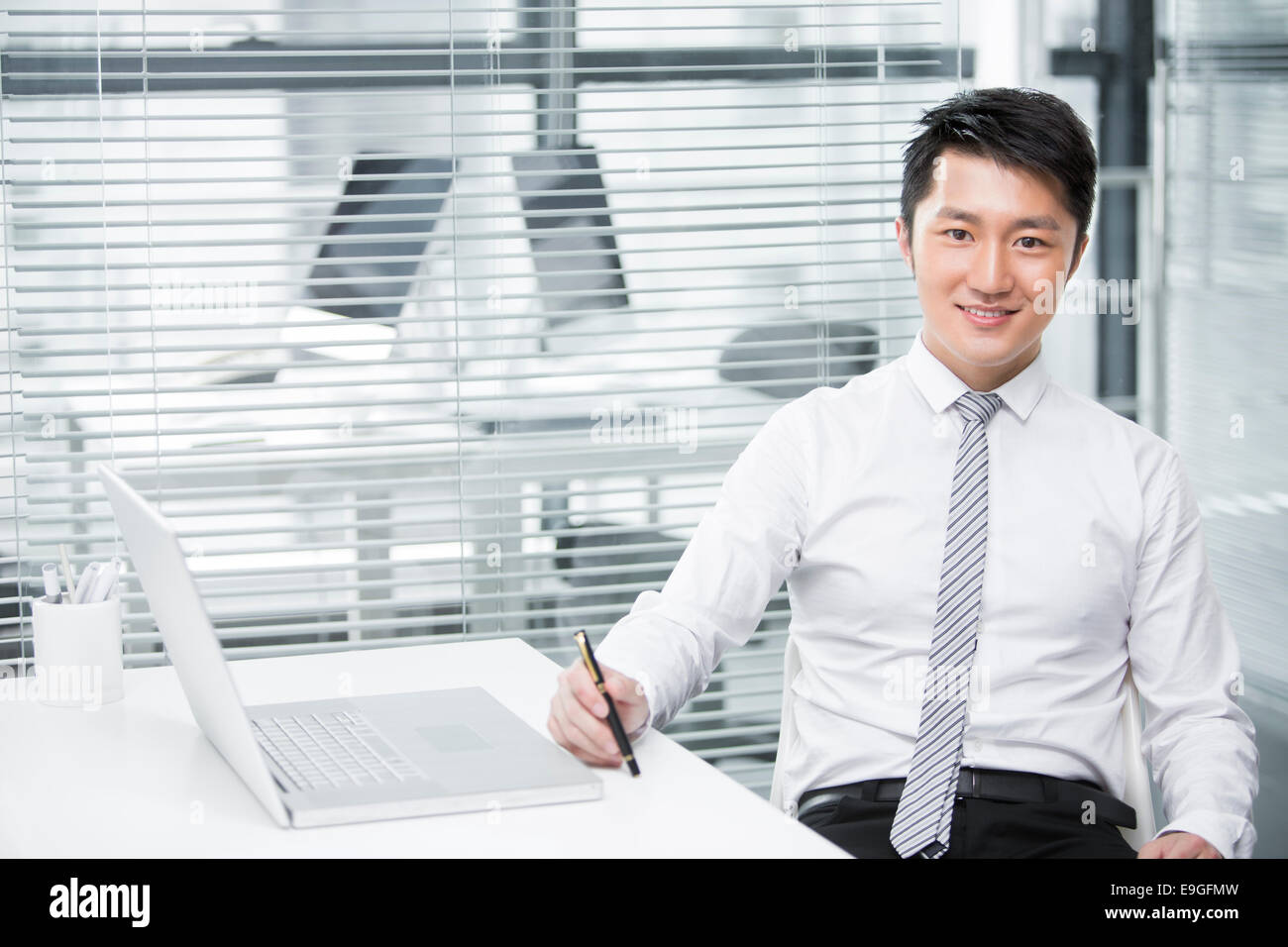 Young businessman holding a pen Stock Photo - Alamy