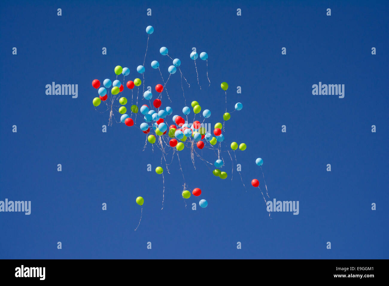 Balloons floating off high in the sky Stock Photo