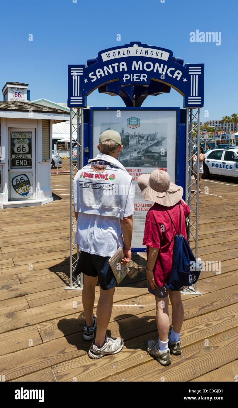 Middle aged couple looking at the information board on Santa Monica Pier, Santa Monica, Los Angeles, California, USA Stock Photo