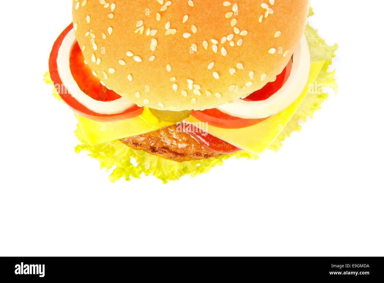 Top view of a burger with cheese, pickles, onion, tomato, ketchup and