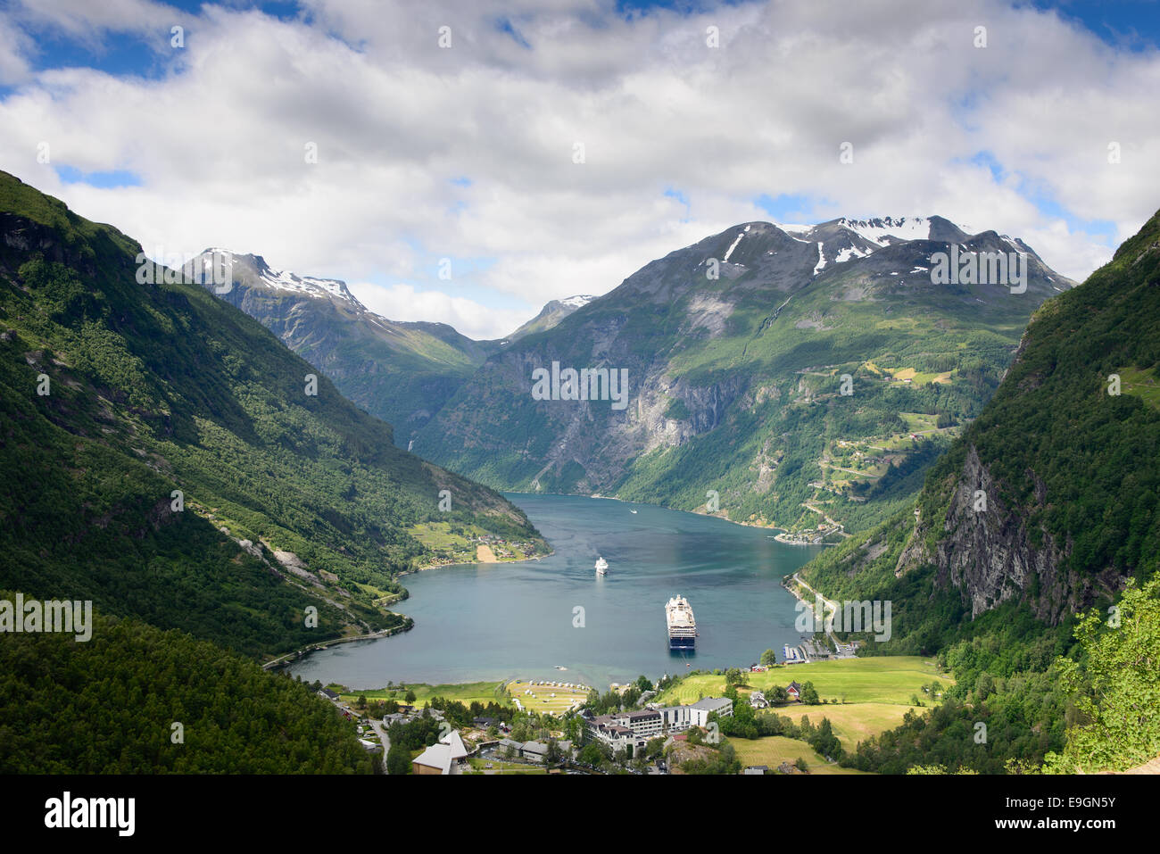 View over a cruise ship in the fjord Geirangerfjord, a UNESCO heritage site, and the village Geiranger in Norway. Stock Photo