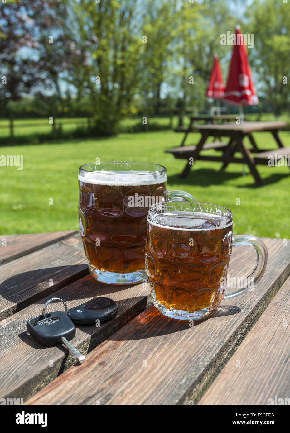 Car keys and pints of beer on a wooden beer garden table Stock Photo