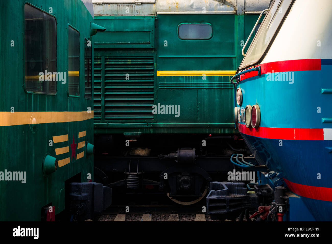 Details of electrical locomotives head to head on the rails. Play or green, red, yellow, blue and white colors Stock Photo