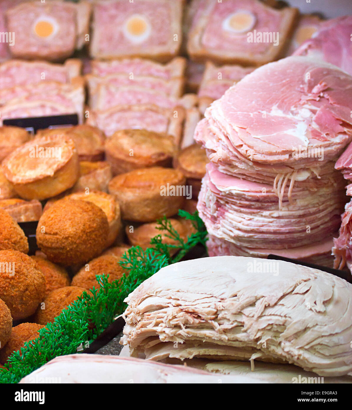 Sliced meats and a selection of various local products on display in the meat counter at a butchers or delicatessen Stock Photo