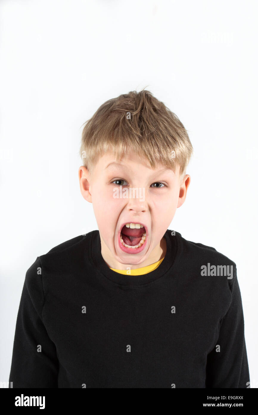 Young boy having a tantrum, screaming at camera, on white Stock Photo
