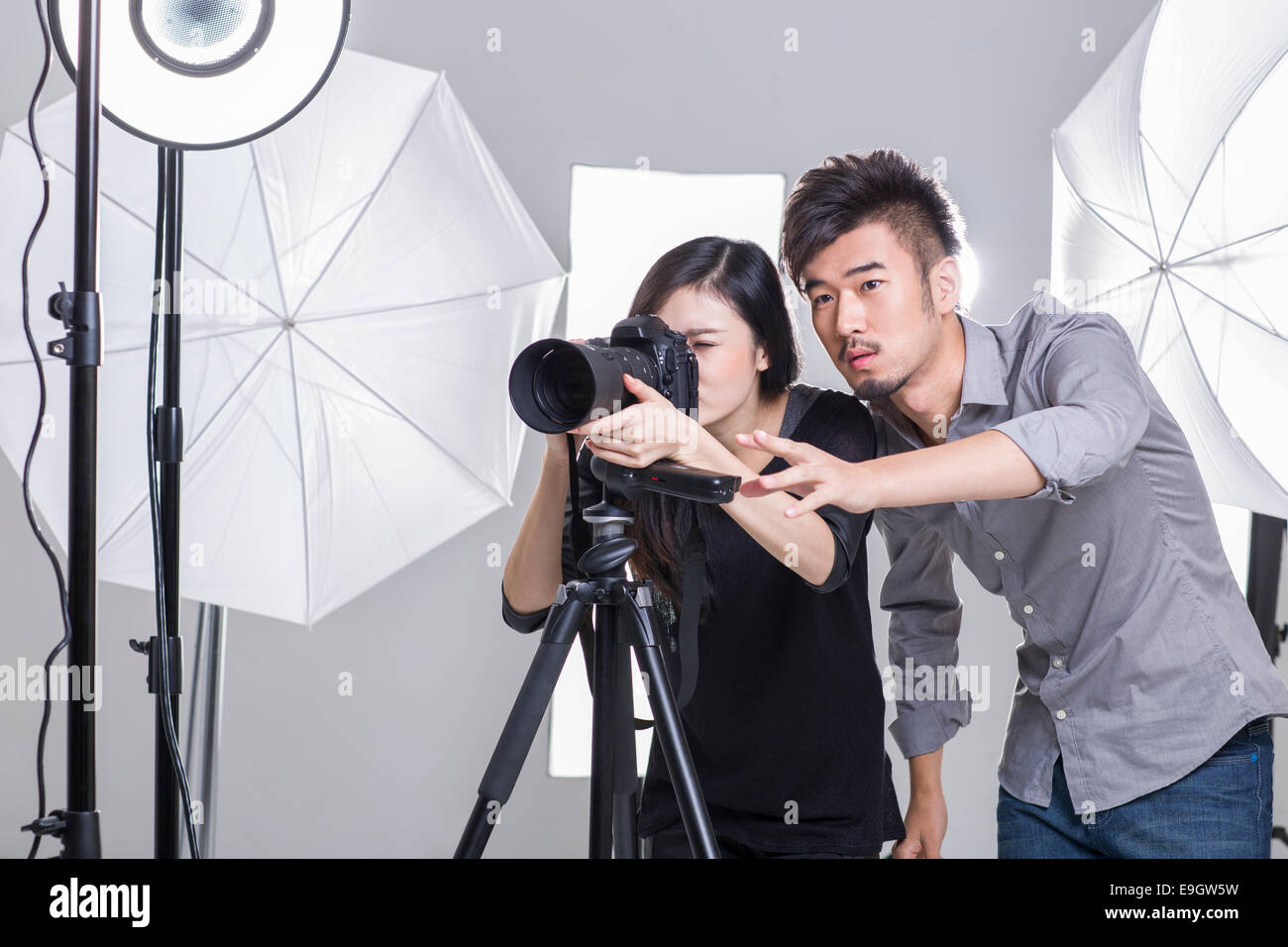 Two photographers taking picture in studio Stock Photo Alamy