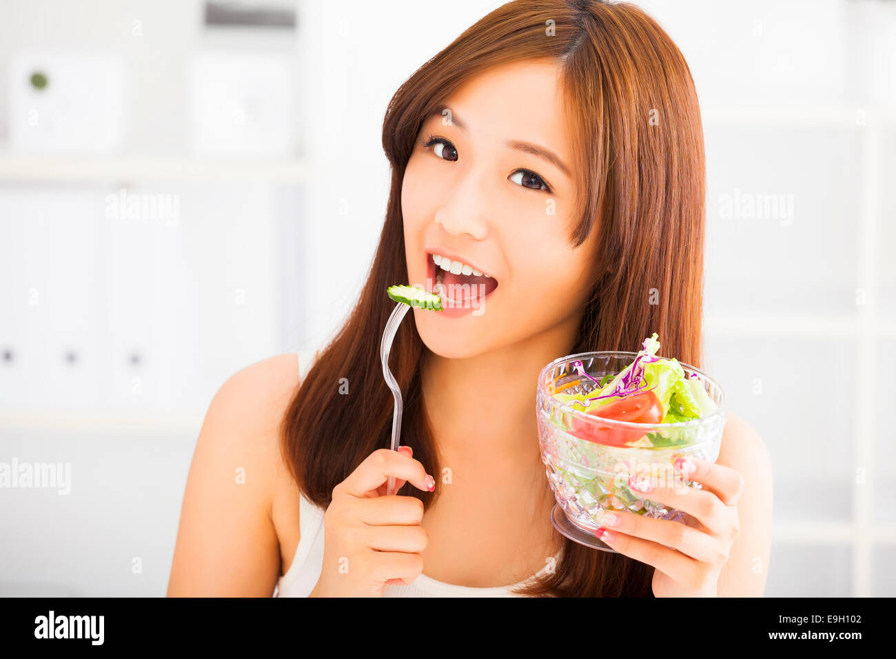 smiling young woman eating fruits and salad. healthy eating concept Stock Photo