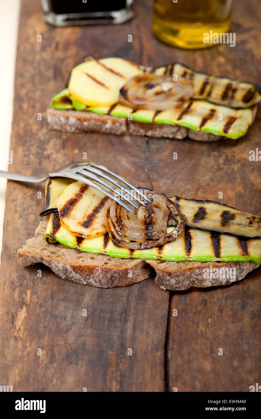 grilled vegetables on rustic  bread over wood table Stock Photo