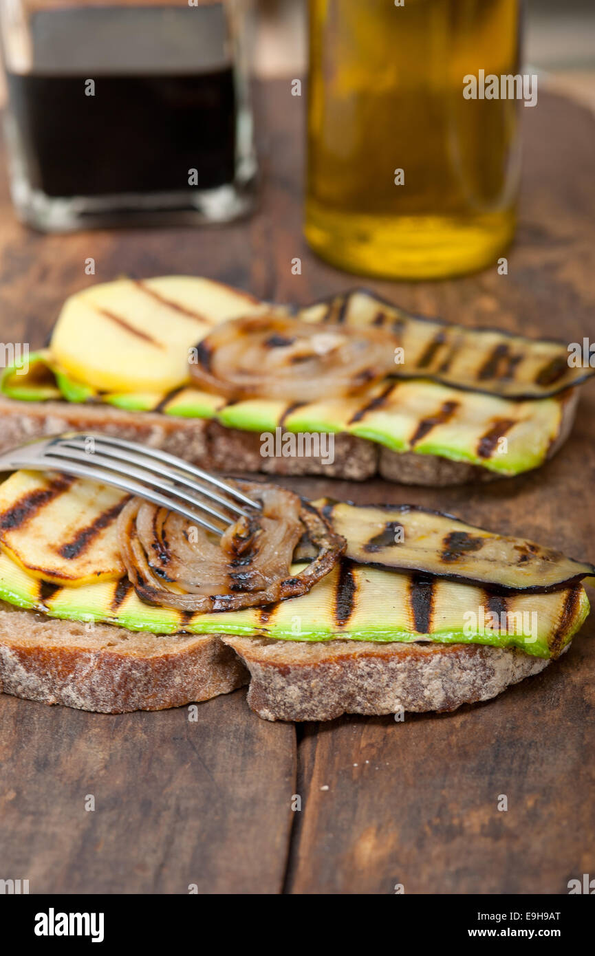 grilled vegetables on rustic  bread over wood table Stock Photo