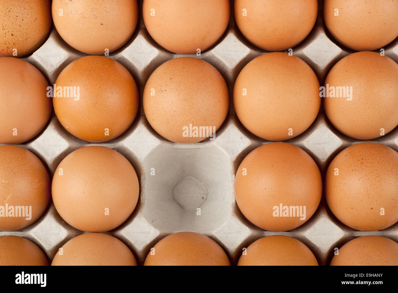 One chicken egg missing from a tray of eggs Stock Photo