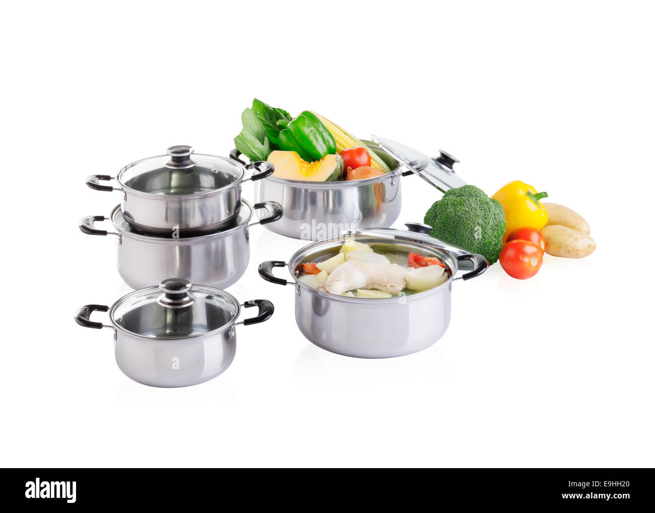 Set of stainless pots with lids and vegetable Stock Photo