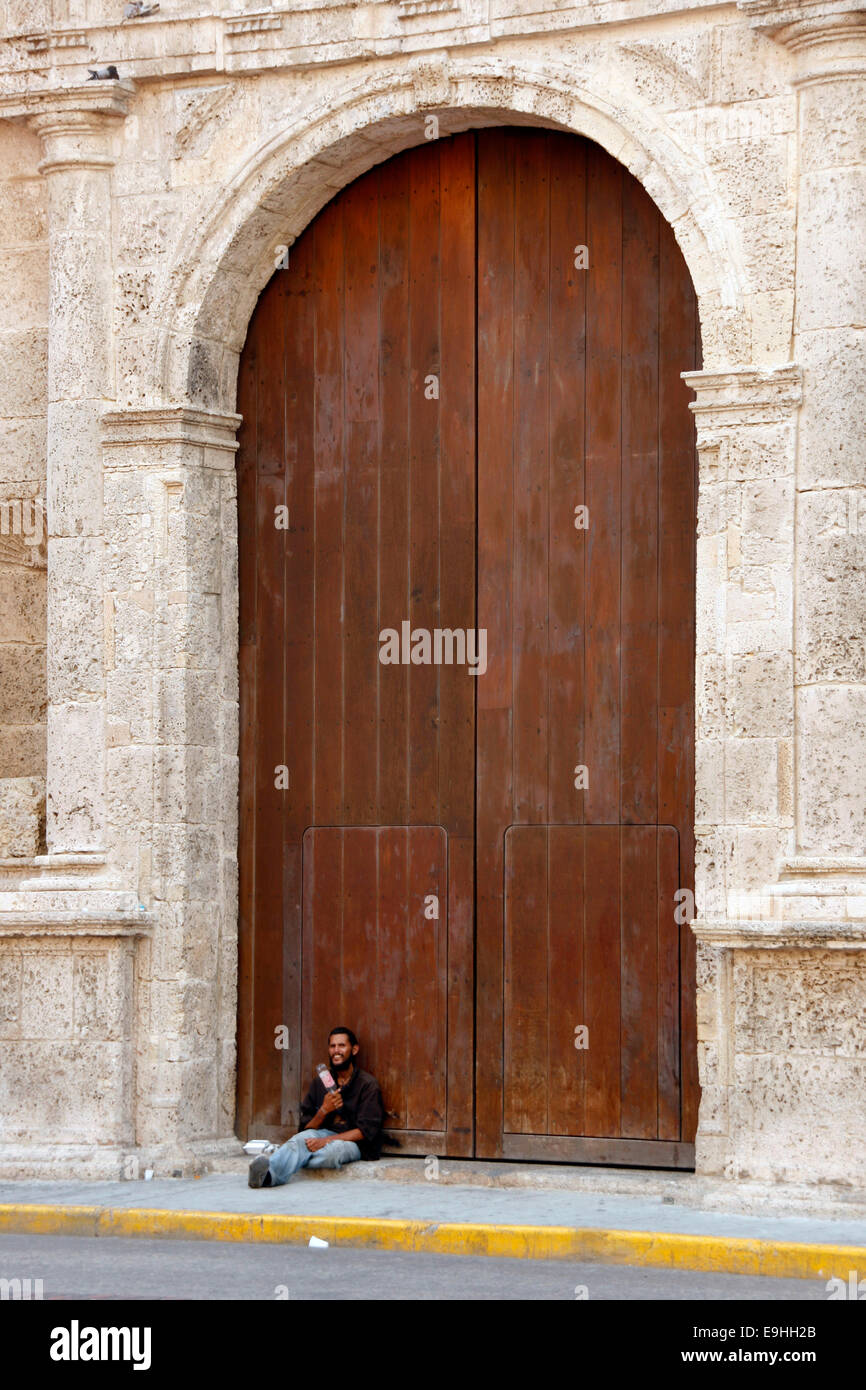 A man leans against the door of a church in Cartagena, Colombia Stock Photo