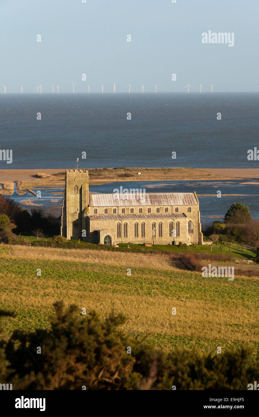 St Nicholas church at Salthouse near Cley, in front of flooded Salthouse Marsh salt marshes on North Norfolk coast. Stock Photo