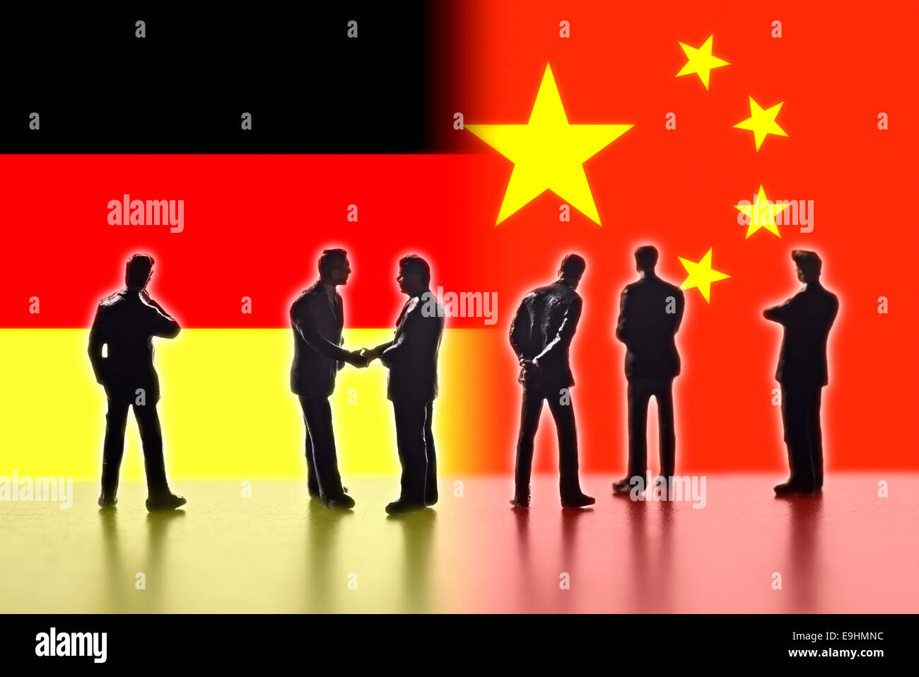 Model figures symbolizing the politicians are faced with the flags of Germany and China. Two of them shake hands. Digital Composite (DC) Stock Photo