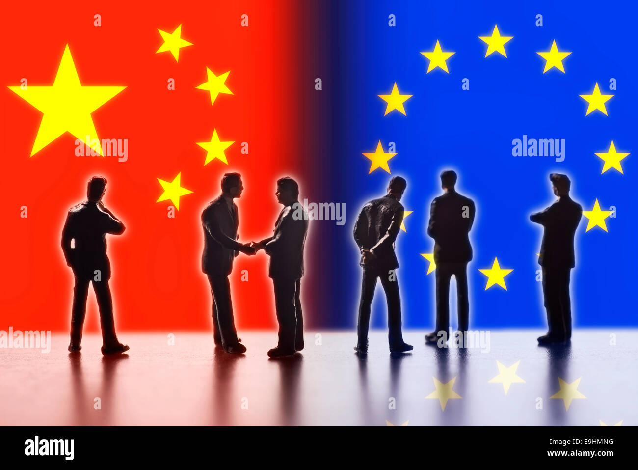 Model figures symbolizing the politicians are faced with the flags of China and the EU. Two of them shake hands. Digital Composite (DC) Stock Photo