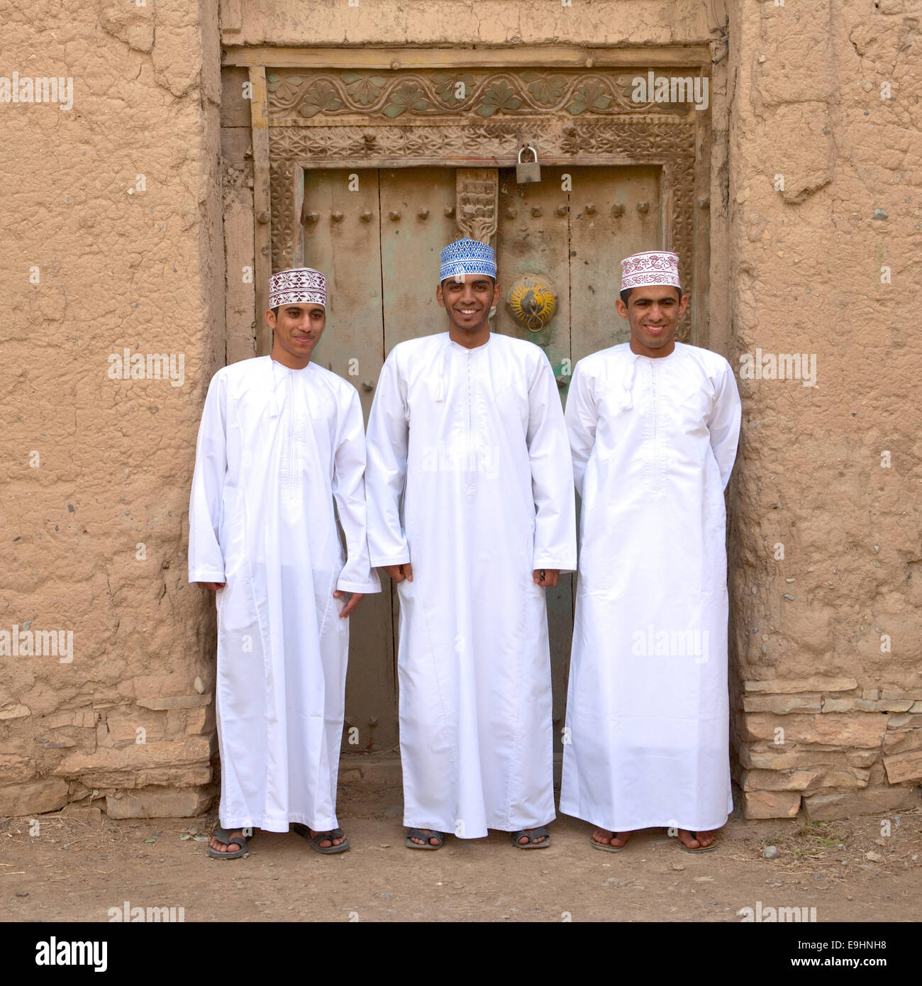 Three young Omani men in traditional dress at the ruins of Birkat Al Mouz in the Nizwa area of