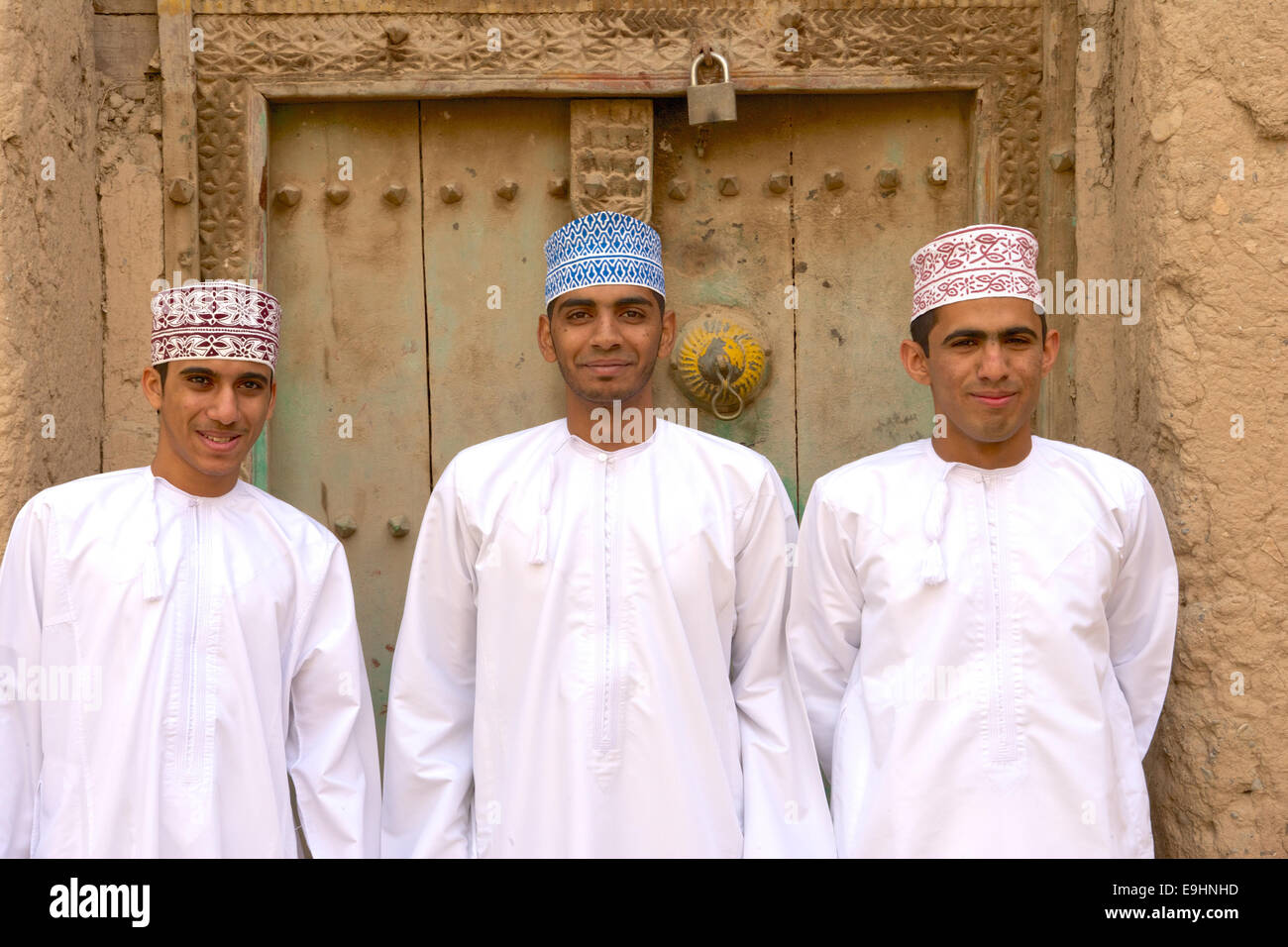 Three young Omani men in traditional dress at the ruins of Birkat Al Mouz in the Nizwa area of the Sultanate of Oman. Stock Photo
