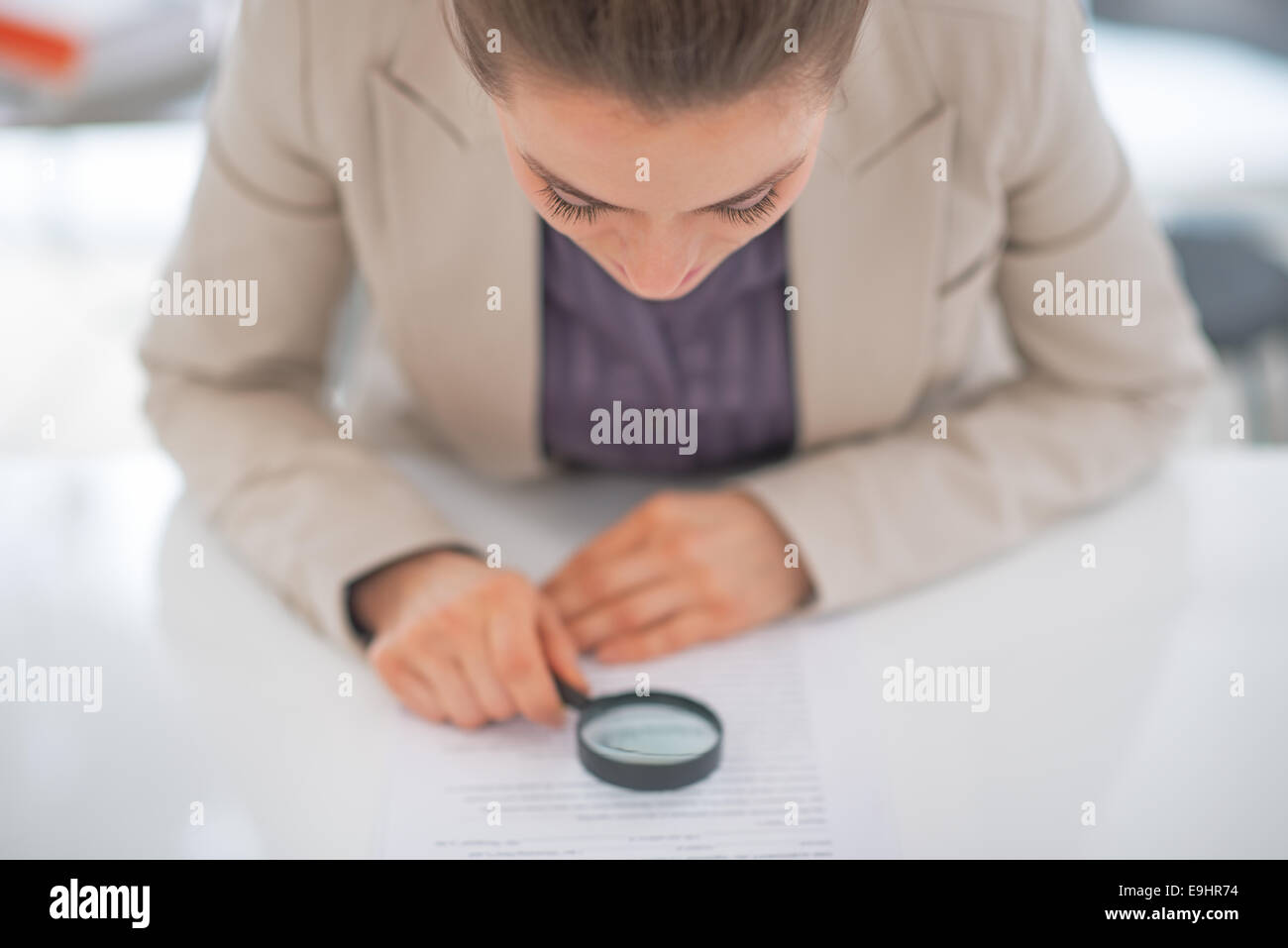 Business woman exploring document with magnifying lens Stock Photo