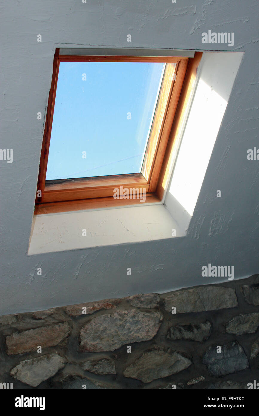 Skylight in a stone country property showing a clear blue sky Stock Photo