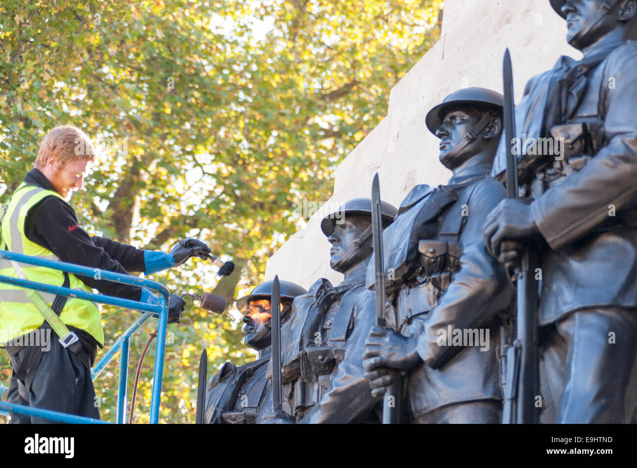 London, UK, 28 October 2014.  Workmen begin the process of 'repatination' on the Guards Division Memorial at Horse Guards Parade.  The bronzes are heated first, before a repatination fluid is applied.  Once dried, they will be waxed and polished.  Each bronze Guardsman is representative of a typical soldier from each of the five divisions: Grenadiers, Coldstreams, Scots, Welsh and Irish Guards.  The memorial commemorates 14,000 Guardsmen who died in the Great War and will be a centrepiece of the forthcoming WW1 centenary event.   Credit:  Stephen Chung/Alamy Live News Stock Photo