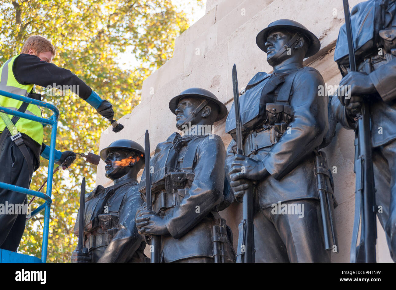 London, UK, 28 October 2014.  Workmen begin the process of 'repatination' on the Guards Division Memorial at Horse Guards Parade.  The bronzes are heated first, before a repatination fluid is applied.  Once dried, they will be waxed and polished.  Each bronze Guardsman is representative of a typical soldier from each of the five divisions: Grenadiers, Coldstreams, Scots, Welsh and Irish Guards.  The memorial commemorates 14,000 Guardsmen who died in the Great War and will be a centrepiece of the forthcoming WW1 centenary event.   Credit:  Stephen Chung/Alamy Live News Stock Photo