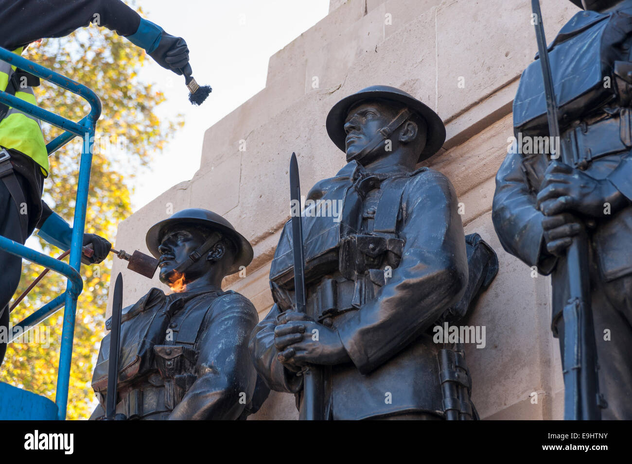 London, UK, 28 October 2014.  Workmen begin the process of 'repatination' on the Guards Division Memorial at Horse Guards Parade.  The bronzes are heated first, before a repatination fluid is applied.  Once dried, they will be waxed and polished.  Each bronze Guardsman is representative of a typical soldier from each of the five divisions: Grenadiers, Coldstreams, Scots, Welsh and Irish Guards.  The memorial commemorates 14,000 Guardsmen who died in the Great War and will be a centrepiece of the forthcoming WW1 centenary event.   Credit:  Stephen Chung/Alamy Live News Stock Photo