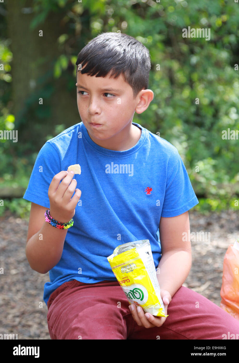 Boy eating a packet of crisps Stock Photo