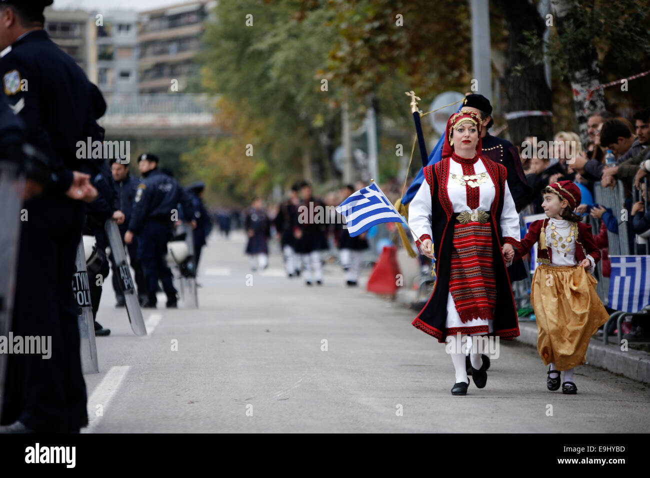 Thessaloniki, Greece. 28th October, 2014. A girl dressed in a traditional costume holds the hand of a woman in traditional military uniform during a parade. The military parade commemorating Greece's entry into World War II has been held in Thessaloniki, Greece on October 28, 2014 Credit:  Konstantinos Tsakalidis/Alamy Live News Stock Photo