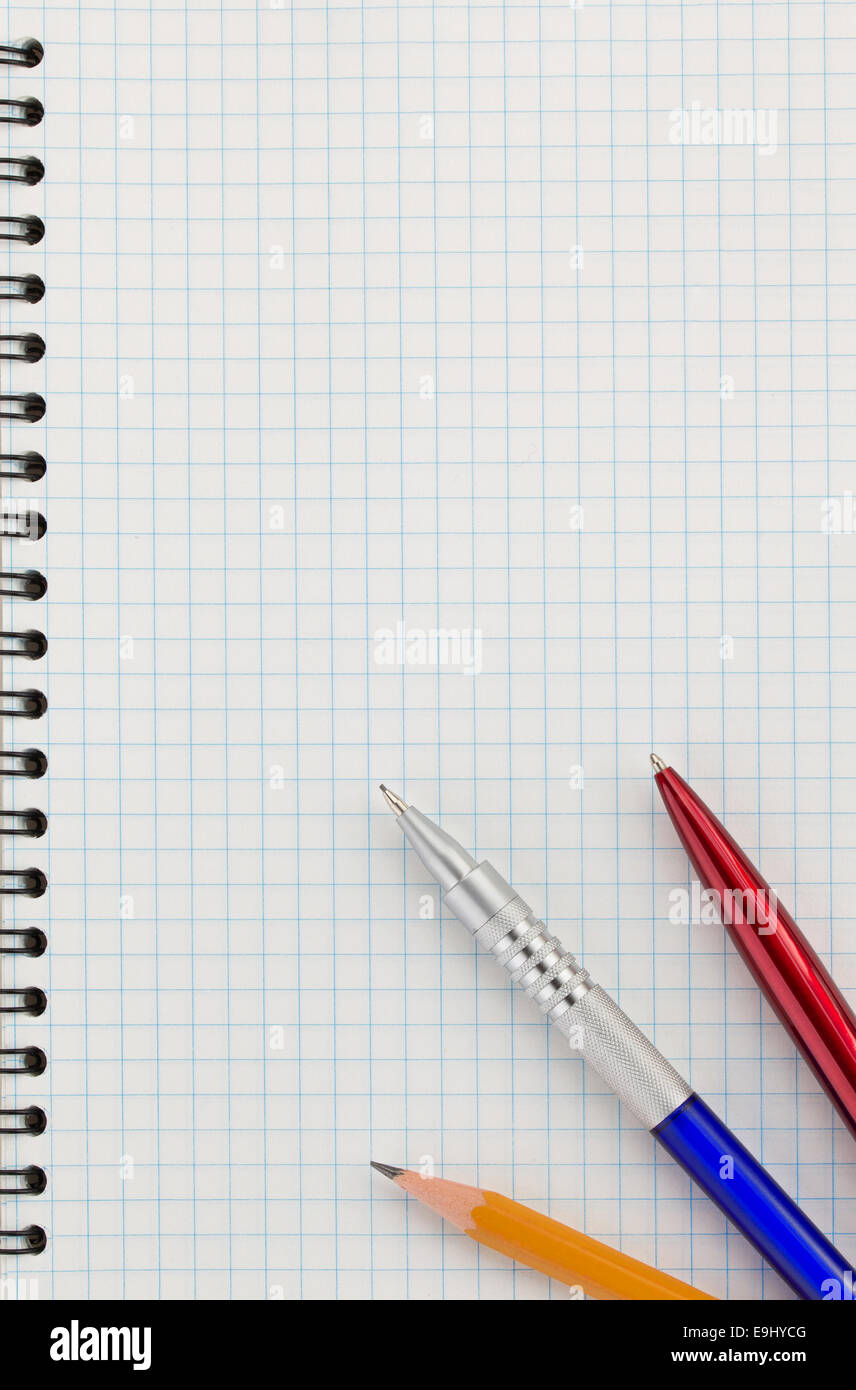 pen and pencil at checked paper of notebook Stock Photo - Alamy
