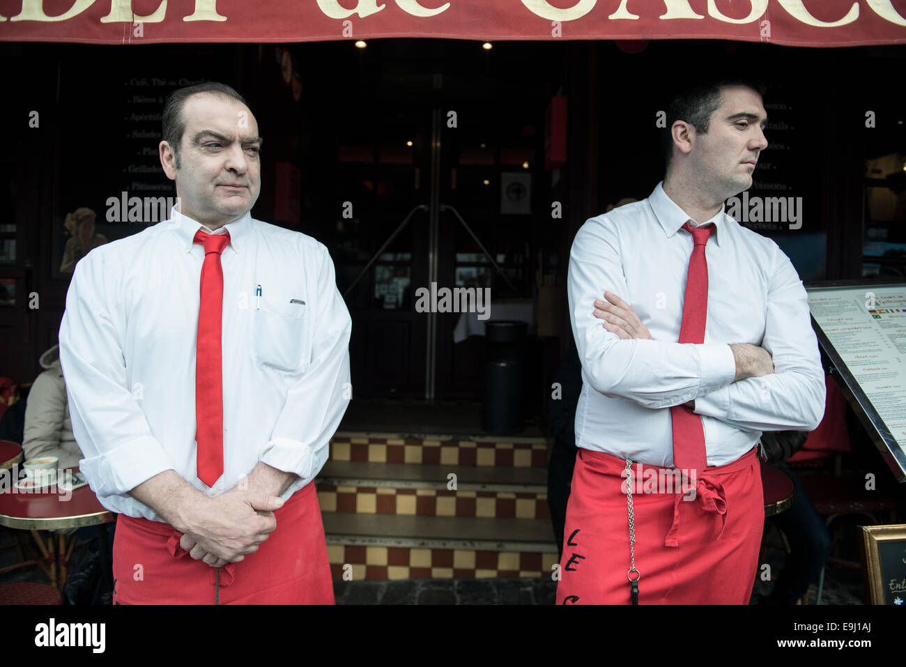 two male french waiters standing outside a french restaurant in paris Stock Photo