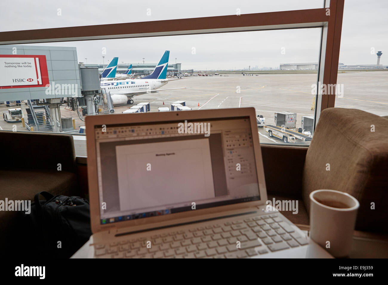 laptop with word document showing meeting agenda in airport business lounge in canada Stock Photo
