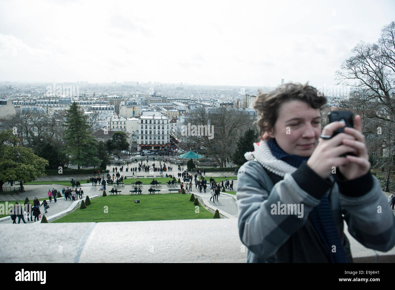 a real person / tourist taking a photo at the sacre coeur in paris at a well known tourist destination Stock Photo