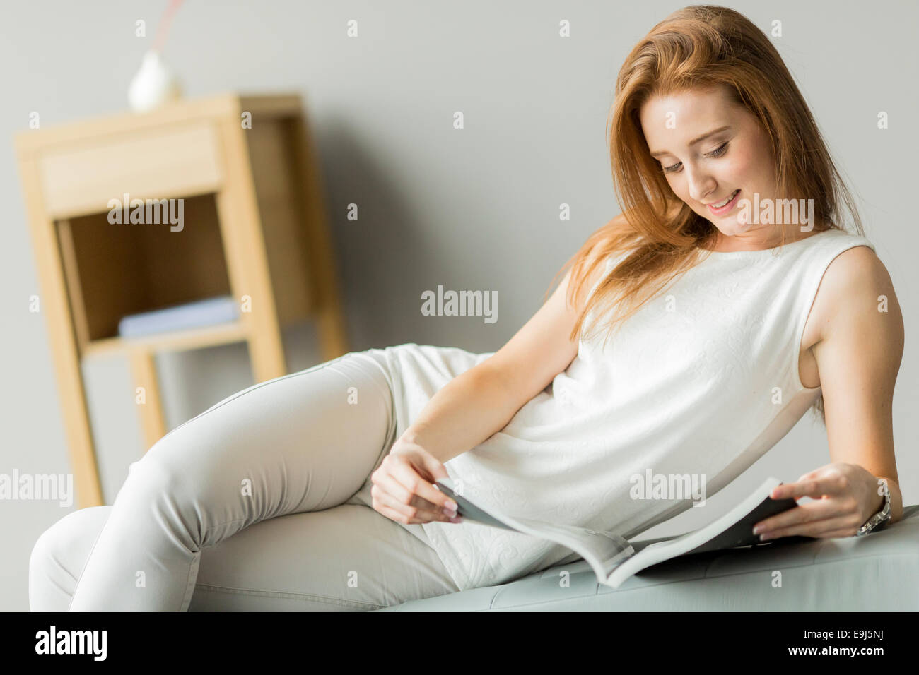 Young woman reading a book in the room Stock Photo - Alamy