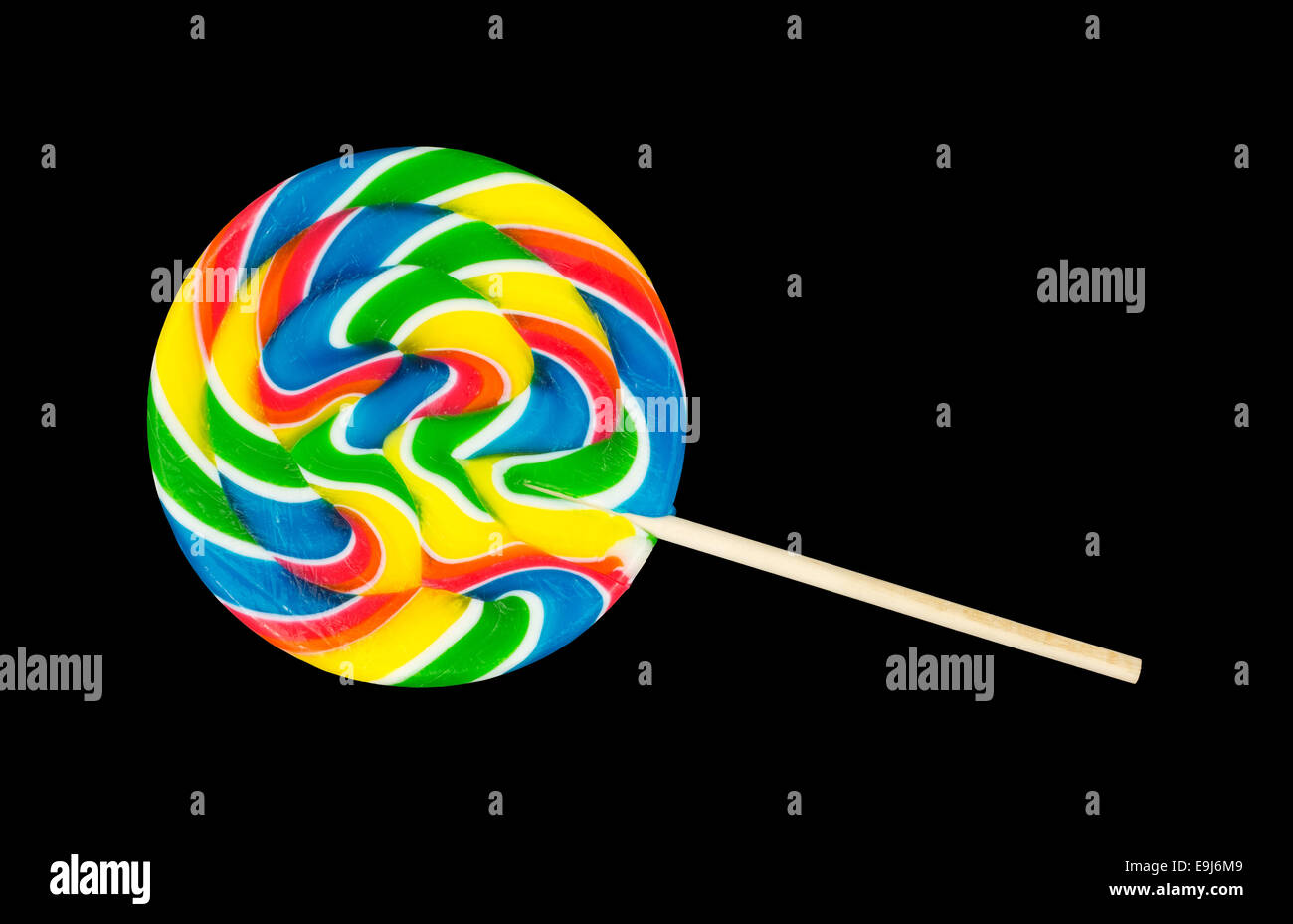 A large colorful lollipop with a wood stick handle on a black background. Stock Photo