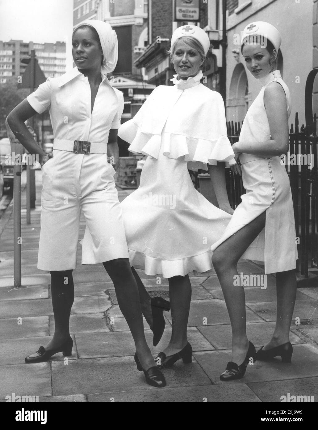 Sep 17, 1971 - London, England, United Kingdom - Jorn Langberg, designer of Christian Dior, London, has designed three new uniforms with the exclusive and feminine Dior look for nurses. They were on show at the London Nursing Exhibition at Seymour Hall. L-R CLAUDETTE wears a culotte in white drill with a long front zipper. HEIDI wears a frilly dress and cap in white cotton drill and MARION wears a sleeveless side buttoning culotte dress in white drill with a semi-discreet and functional slit at the side. Drill is stout durable cotton fabric with a strong bias (diagonal) in the weave. Light wei Stock Photo