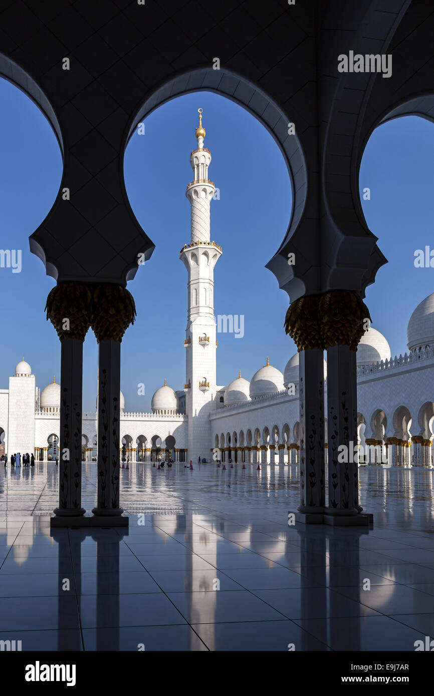 View of minerat of Sheikh Zayed Mosque through the arches in courtyard of mosque. Abu Dhabi, UAE. Stock Photo