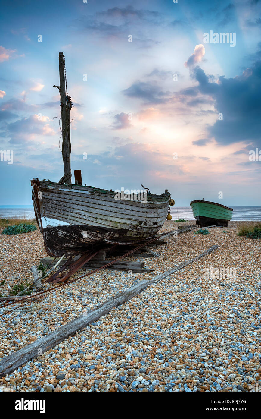 Old wooden fishing boats on a shingle beach at Lydd on Sea in Kent ...