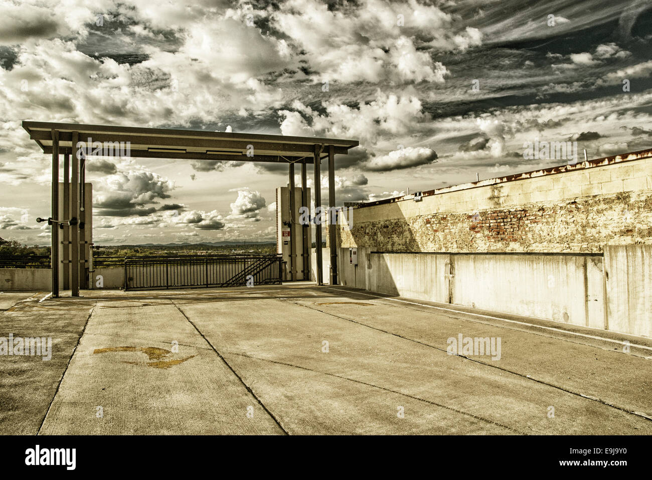 A covered stairway on the top floor of a parking garage with a beautiful mixed cloud filled sky in the background. Stock Photo