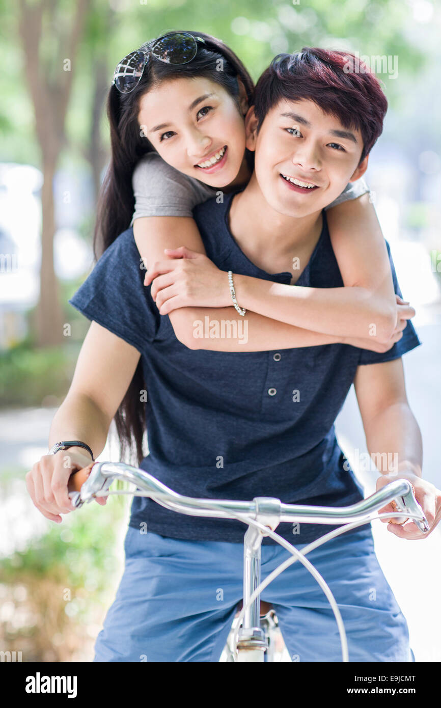 Young couple riding bicycle at campus Stock Photo Alamy