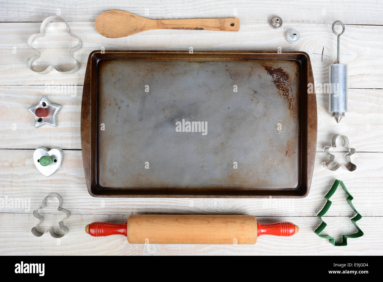 Overhead shot of a group of items for baking Christmas Cookies surrounding an empty cookie sheet. Horizontal format on a  rustic Stock Photo