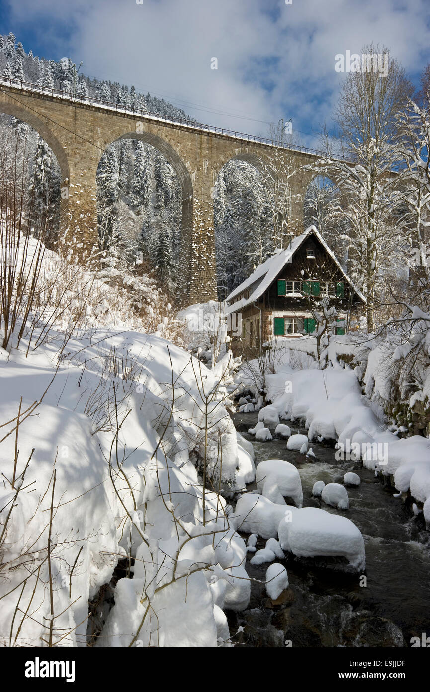 Snow-covered creek with a Black Forest house and a railway bridge, Ravenna gorge, Black Forest, Baden-Württemberg, Germany Stock Photo