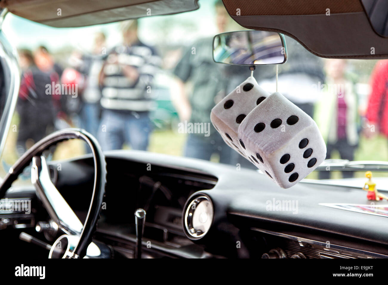 Black and white furry fuzzy dice hanging from rear view mirror