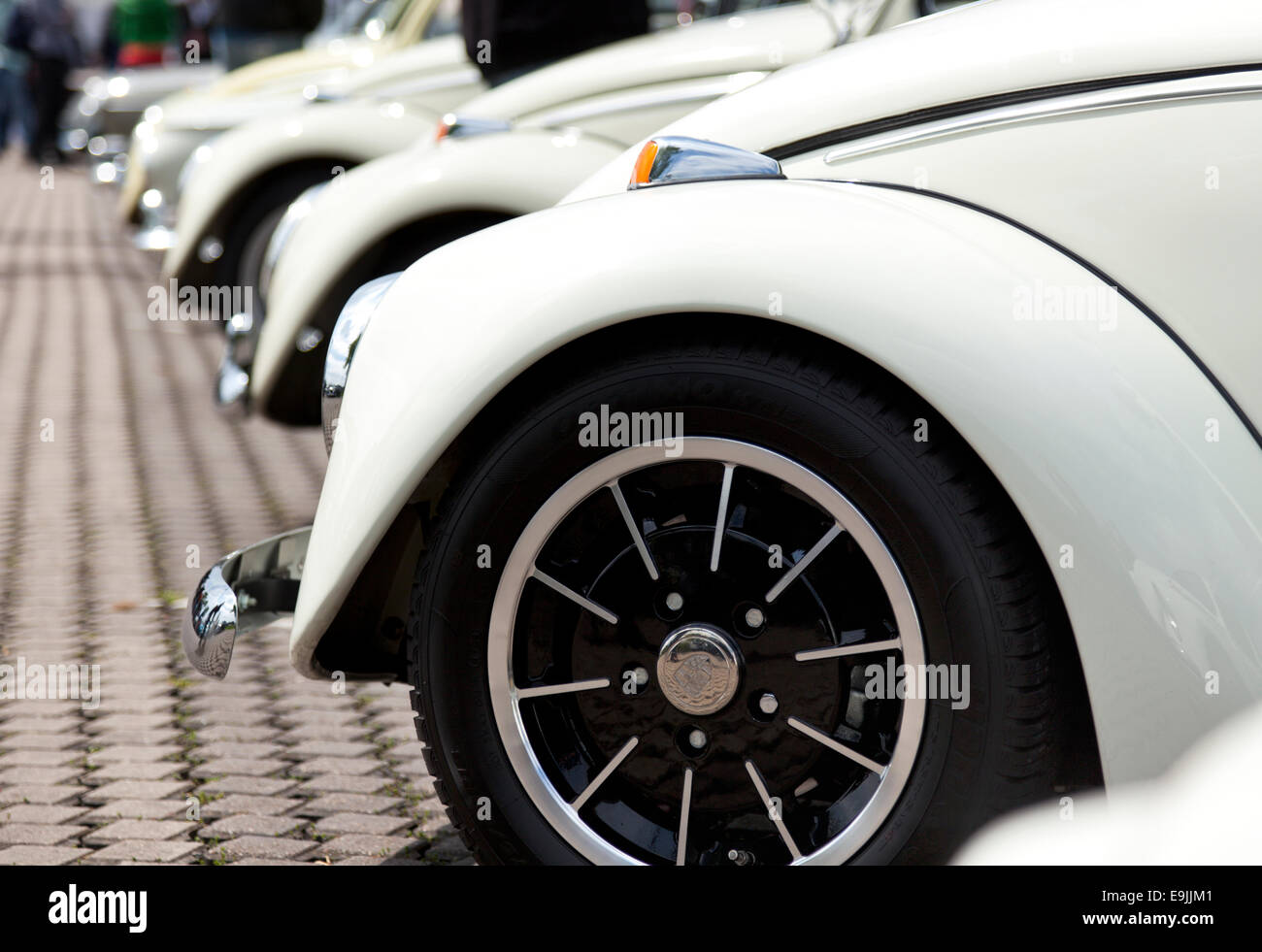 Row of vintage Volkswagen Beetle cars, closeup of fender and Porsche design wheel, shallow depth of field Stock Photo