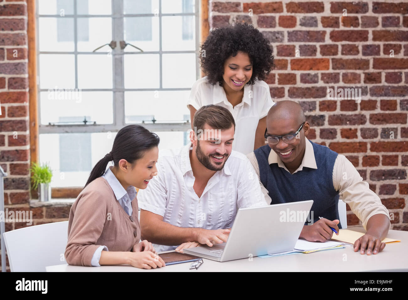 Creative business team using laptop in meeting Stock Photo - Alamy