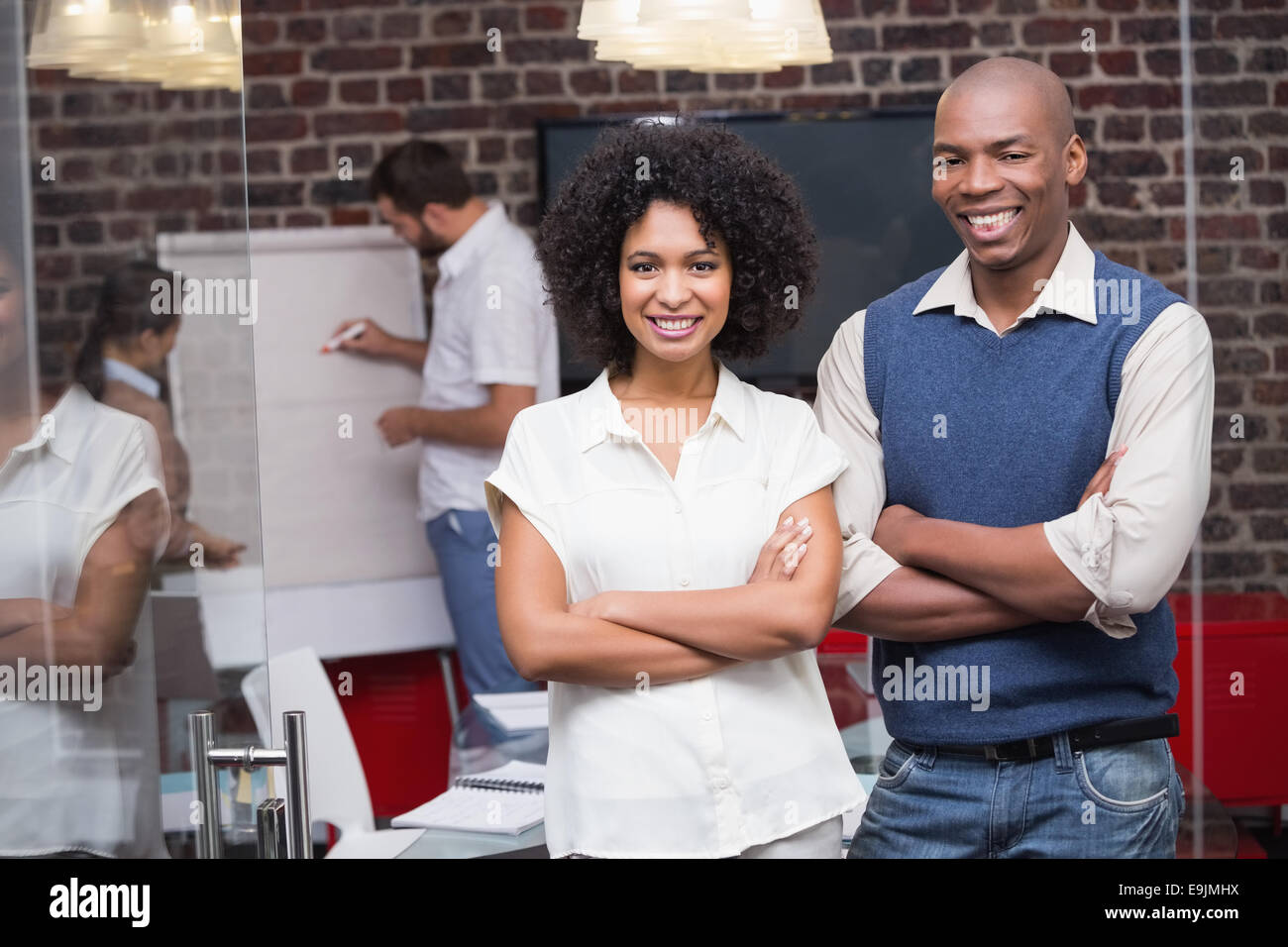 Confident young business people with arms crossed in office Stock Photo ...